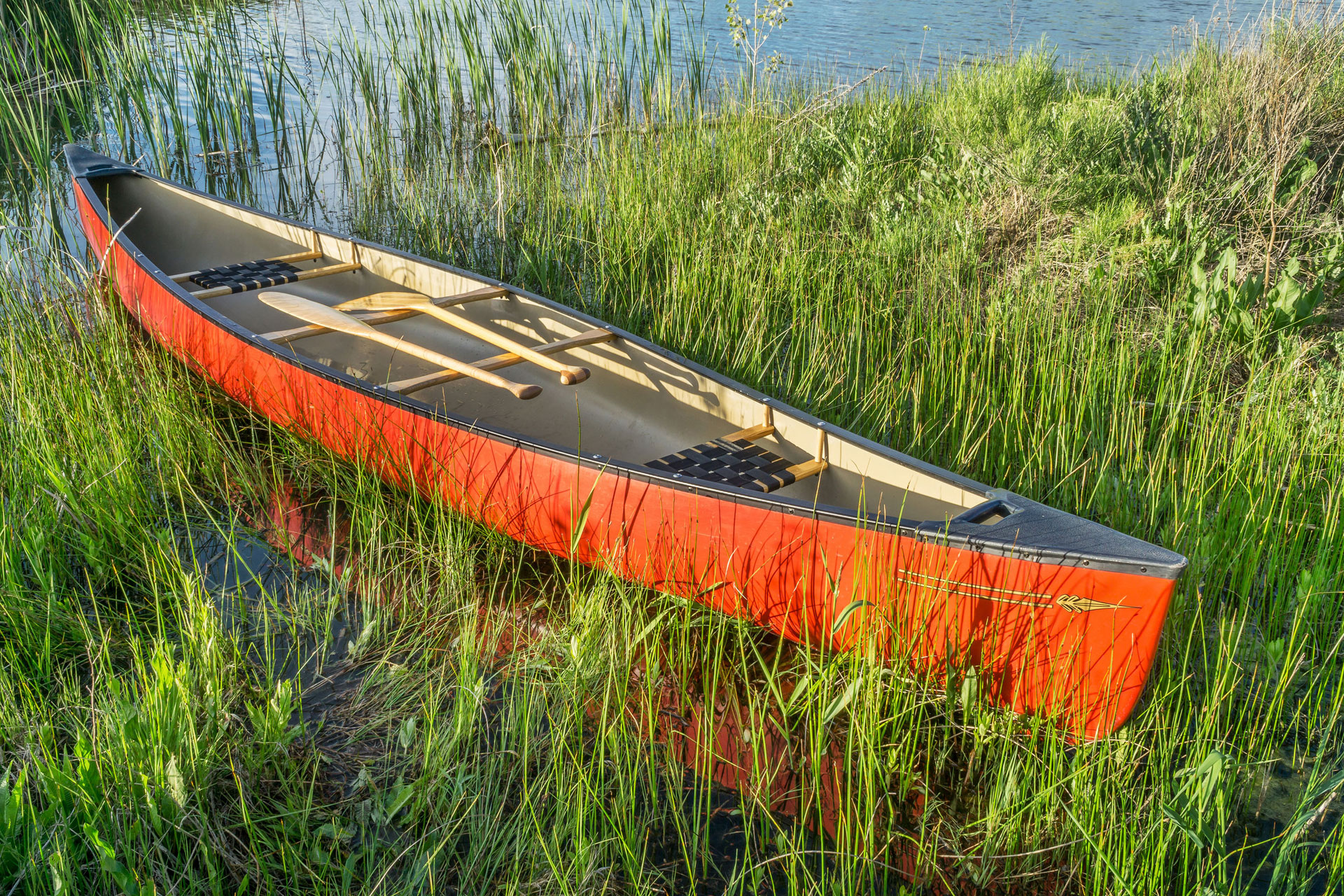 Ein rotes Ruderboot liegt am Ufer